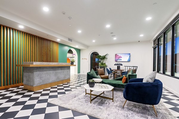 Clubhouse at Fitz on Fairfax Apartments: Modern recreational space with stylish seating and large screen TV