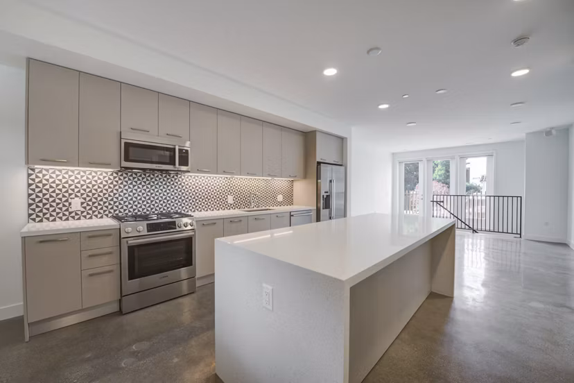 Modern kitchen with stainless steel appliances and quartz countertops at Fitz on Fairfax Apartments