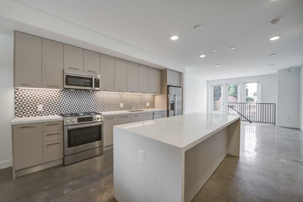 Modern kitchen with stainless steel appliances and quartz countertops at Fitz on Fairfax Apartments