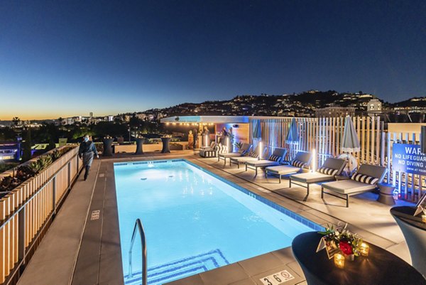 Relaxing pool area with lounge chairs at Fitz on Fairfax Apartments, designed for leisure and social gatherings in luxury community living