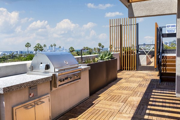 Outdoor grill area at Fitz on Fairfax Apartments with modern seating and dining spaces