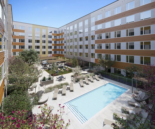 Luxury pool framed by lush greenery at Maxwell Apartments, offering a serene retreat in urban living