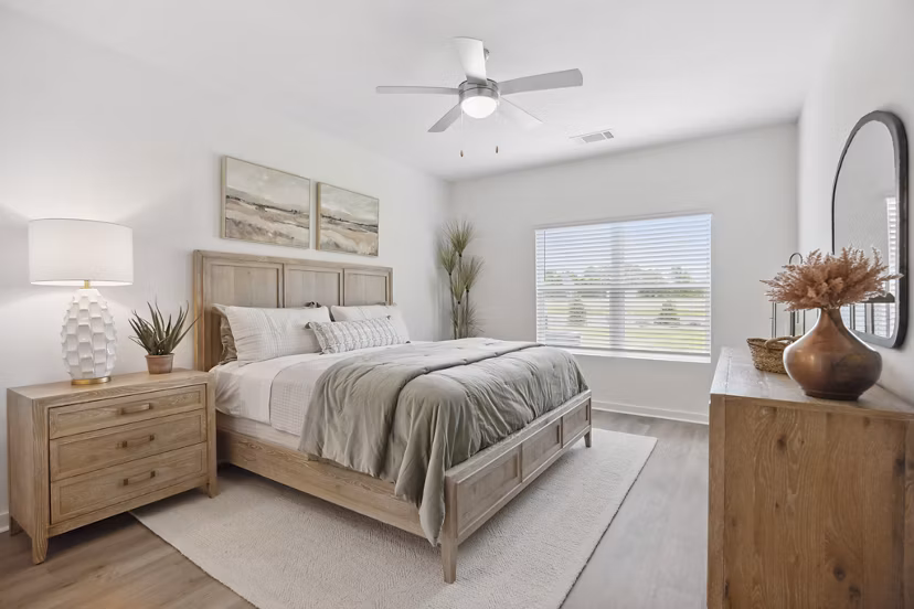 Cozy bedroom featuring modern decor and large windows at River Rock at Dallas Apartments