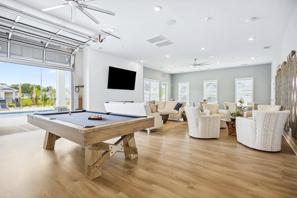 Clubhouse game room with pool tables and lounge seating at River Rock at Shingletree Apartments, perfect for social gatherings and leisure activities