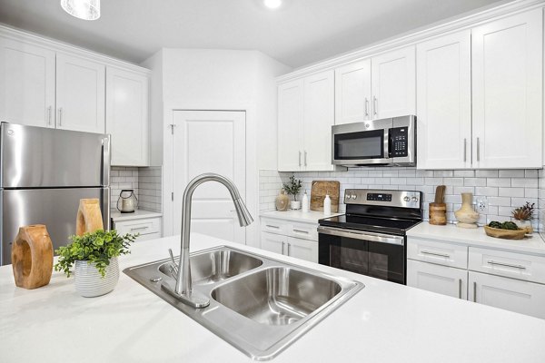 River Rock at Shingletree Apartments: Modern kitchen with stainless steel appliances and granite countertops