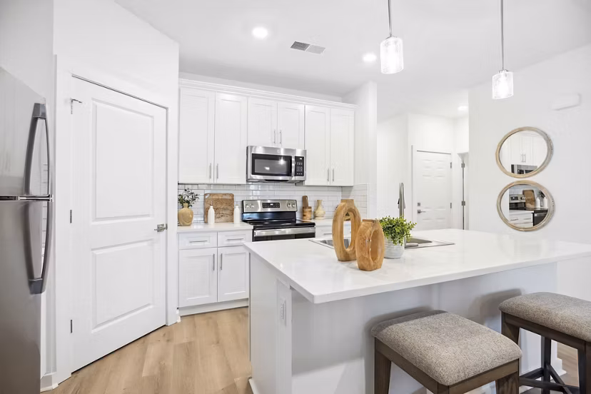 Modern kitchen with stainless steel appliances and granite countertops at River Rock at Shingletree Apartments