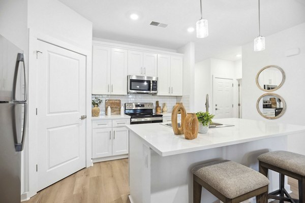 Modern kitchen with stainless steel appliances and granite countertops at River Rock at Shingletree Apartments