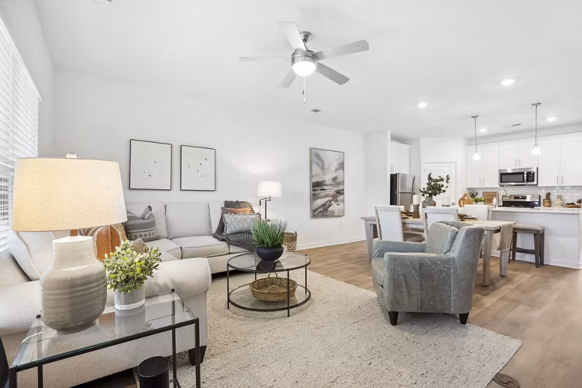 Modern living room with cozy seating and natural light at River Rock at Shingletree Apartments