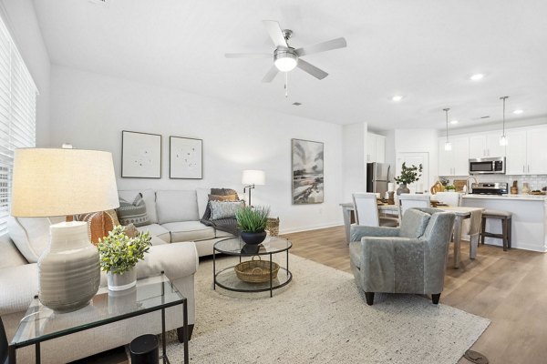 Modern living room with cozy seating and natural light at River Rock at Shingletree Apartments