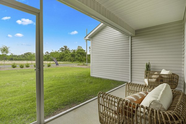 Patio with cozy seating and lush greenery at River Rock at Shingletree Apartments