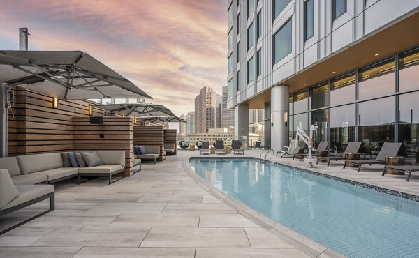 Serene outdoor pool area at The Sudbury Apartments offering sun loungers and landscaped surroundings