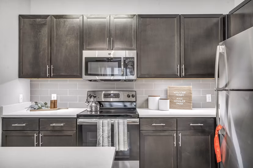 Axis Kessler Park Apartments: Modern kitchen featuring stainless steel appliances and granite countertops in luxury Greystar community