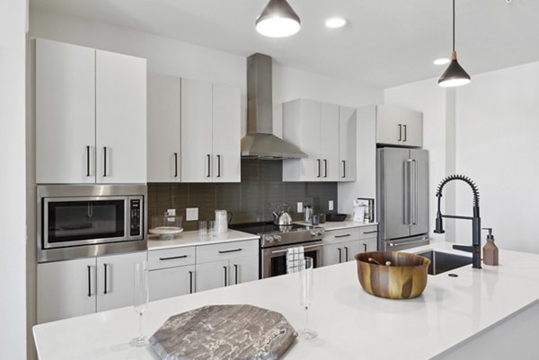 Modern kitchen with stainless steel appliances and granite countertops in Starlight Apartments