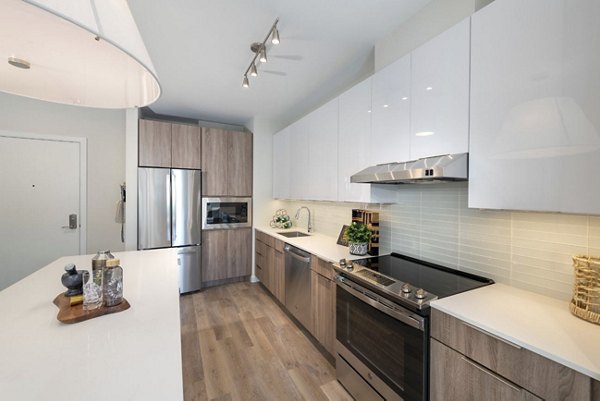 Modern kitchen featuring stainless steel appliances and granite countertops in Matson Mill Apartments