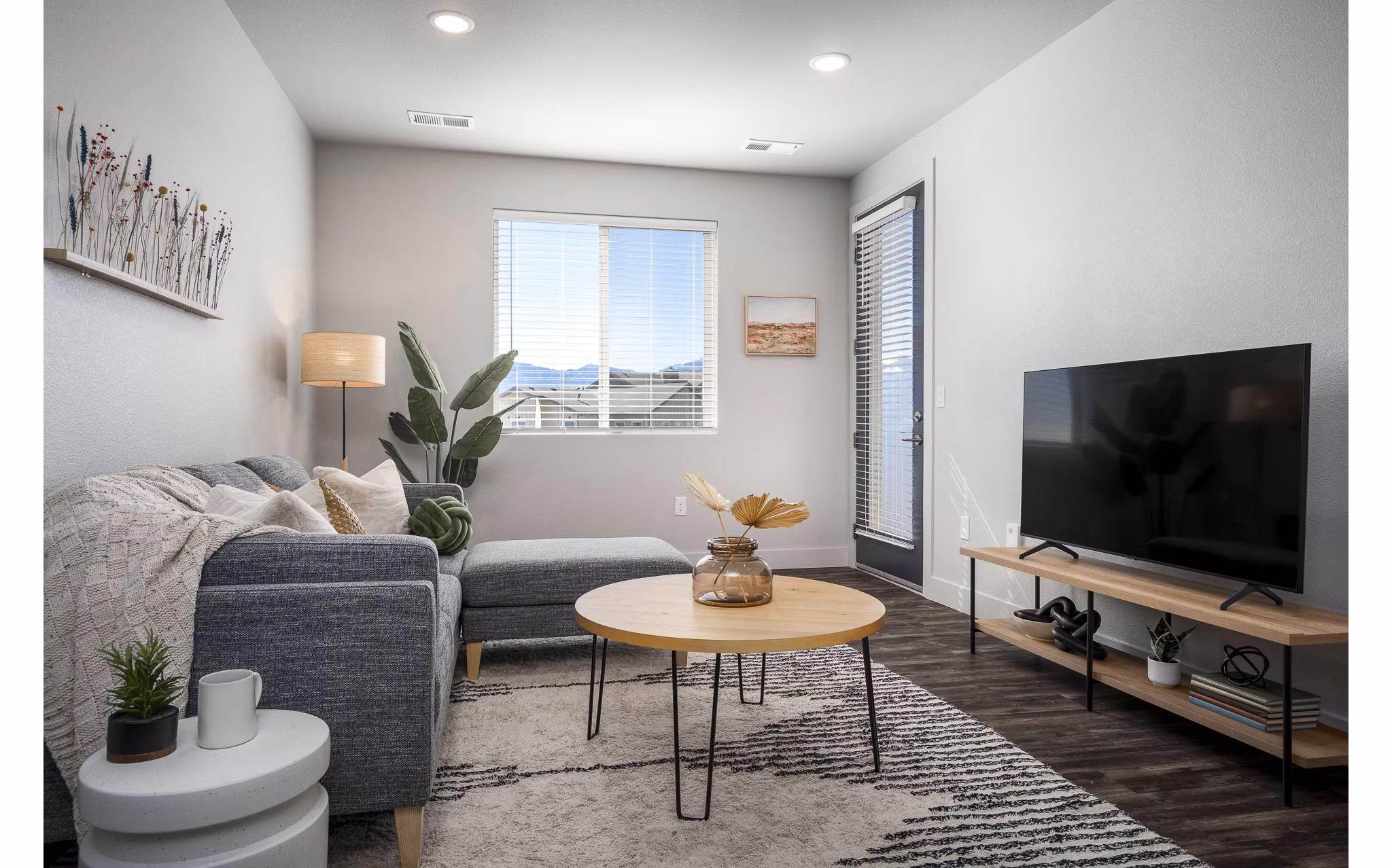 Cozy living room with plush seating and natural light at The Flats at Aero Park Apartments