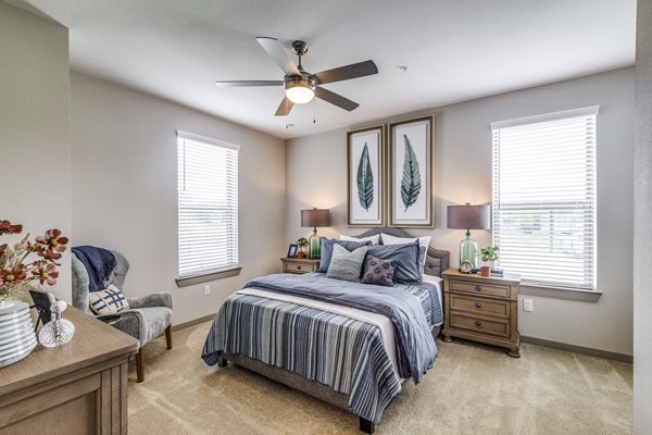 Cozy bedroom featuring stylish decor and large windows at Alders Cross Creek Apartments