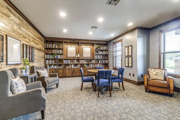 Cozy clubhouse library with plush seating at Alders Cross Creek Apartments, perfect for leisure and study in a luxurious setting