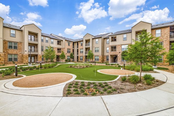 Putting green perfect for practice at Alders Cross Creek Apartments, featuring lush grass and serene surroundings for relaxing and recreational activities