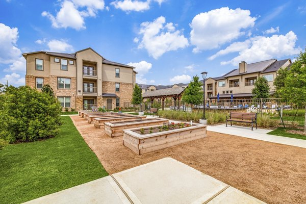 Community garden area with lush greenery at Alders Cross Creek Apartments