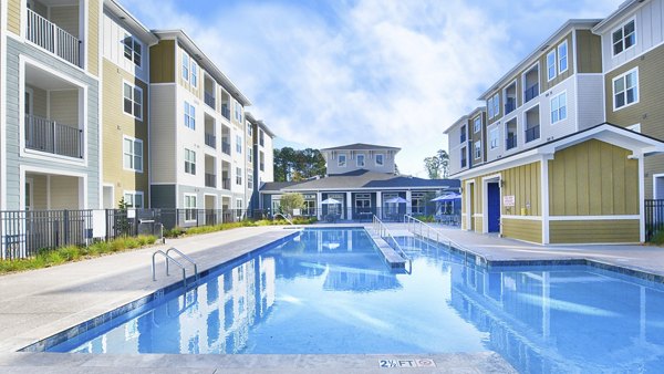 Resort-style pool area at The Aspens Verdae Apartments with lush landscaping