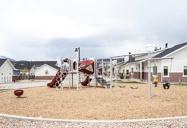 Children's playground at Milano Apartments, featuring colorful play structures and green spaces