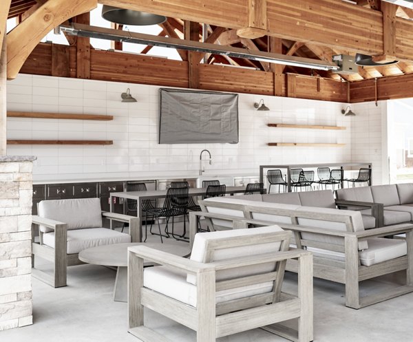 Chic outdoor patio at Milano Apartments featuring stylish seating and lush greenery
