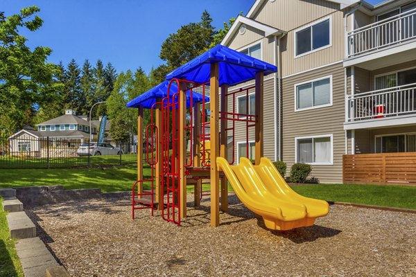 Playground featuring colorful slides and swings at Alaire Apartment Homes apartments