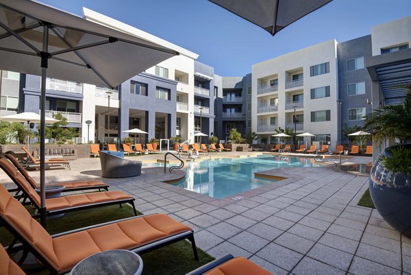 Luxurious poolside retreat at Nexa Apartments featuring stylish loungers and clear blue water, ideal for relaxation and leisure
