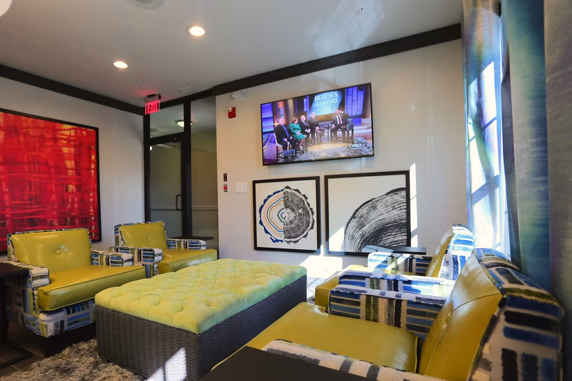 Clubhouse interior at CB Lofts Apartments with modern design elements, stylish seating areas, and vibrant decor