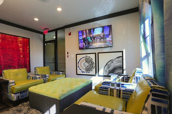 Clubhouse interior at CB Lofts Apartments with modern design elements, stylish seating areas, and vibrant decor