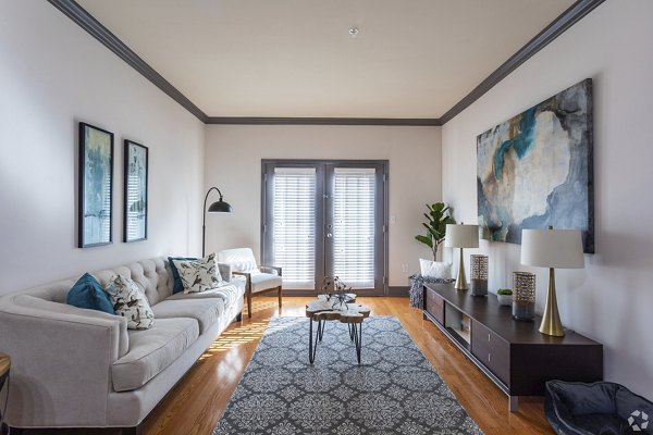 Living room with modern decor and large windows at CB Lofts Apartments