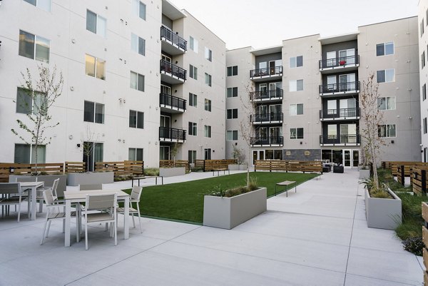 Spacious patio with modern furniture at Milagro Apartments, ideal for outdoor relaxation and entertainment