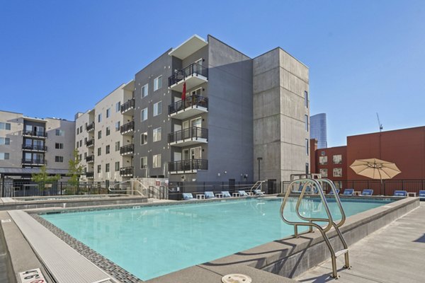 Resort-style pool with lounging area at Milagro Apartments