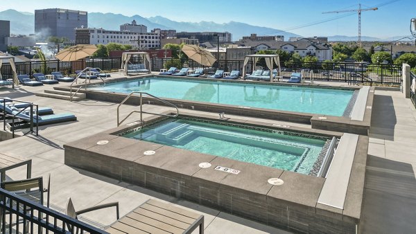 Luxurious outdoor pool with lounge seating at Milagro Apartments