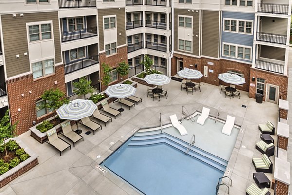 Sun-drenched pool area with lounge chairs at Cedar Flats Apartments, offering luxury relaxation in a vibrant community setting