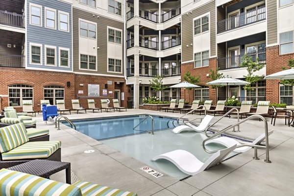 Luxury pool with lounge chairs at Cedar Flats Apartments