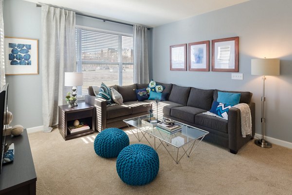 Spacious living room with contemporary furnishings at The Victor Stonebridge Apartments, featuring sleek design and abundant natural light