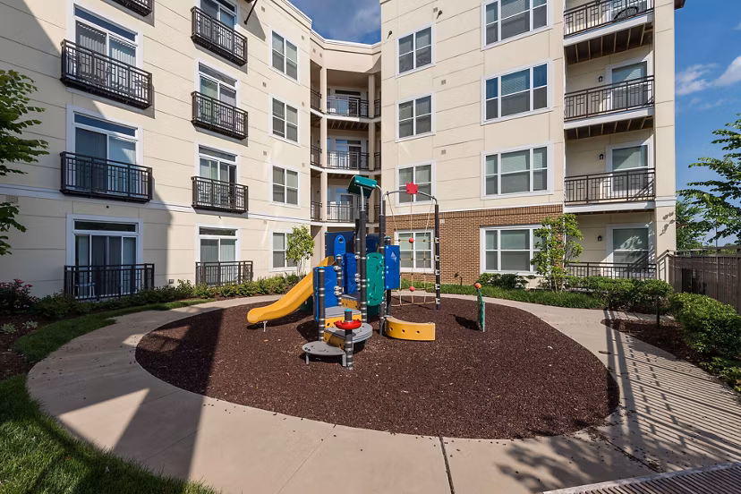 Modern playground featuring slides and swings at The Victor Stonebridge Apartments