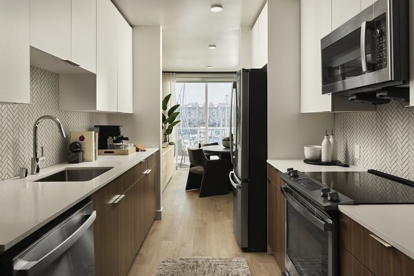 Modern kitchen featuring stainless steel appliances and granite countertops at Dolphin Marina Apartments