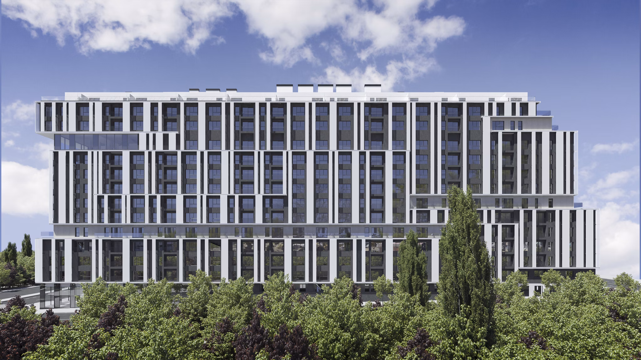 Front facade of Nera Living Atocha surrounded by lush greenery.