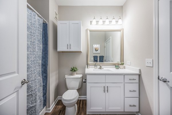 Bathroom with modern fixtures and sleek tile in Jefferson at Dedham Station Apartments, a luxury property offering comfort and style