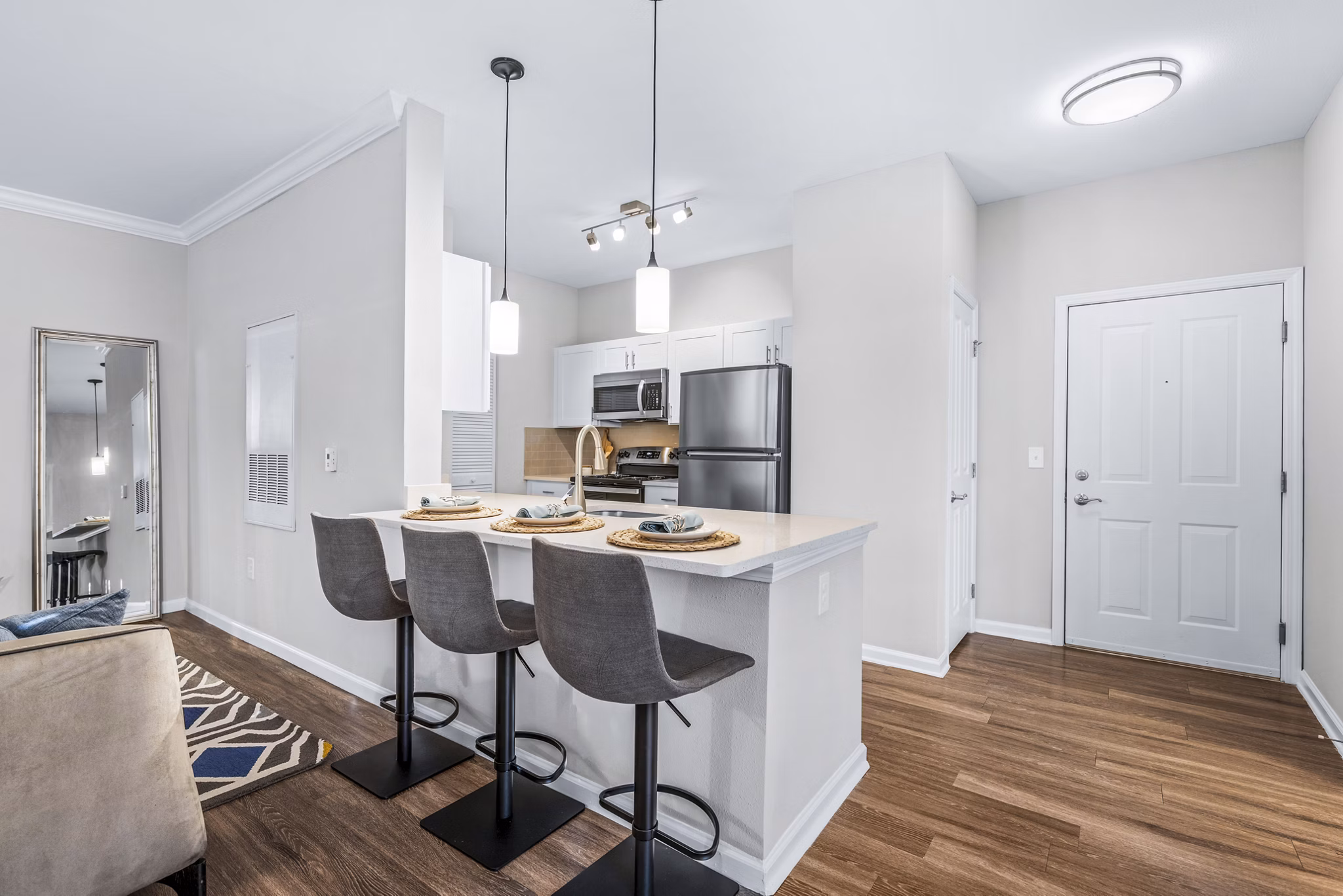 Contemporary entryway and kitchen with sleek countertops in Jefferson at Dedham Station Apartments