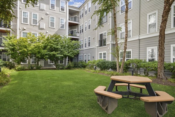 Peaceful courtyard with lush greenery at Jefferson at Dedham Station Apartments offering luxury living near commuter-friendly Dedham station