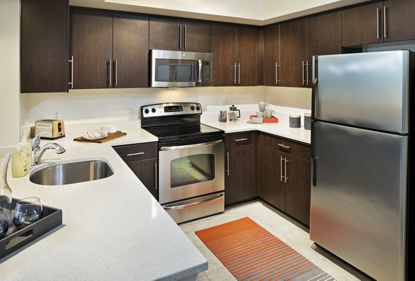 Modern kitchen with stainless steel appliances at 100 Capitol Yards Apartments