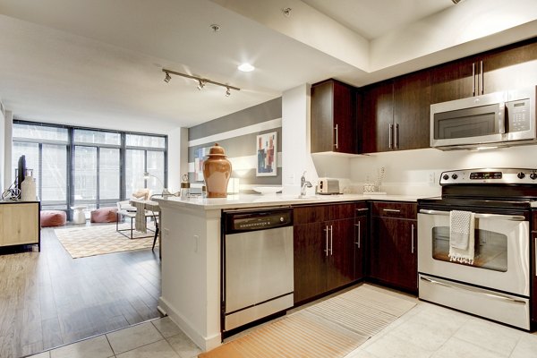 Modern kitchen with stainless steel appliances and granite countertops at 100 Capitol Yards Apartments