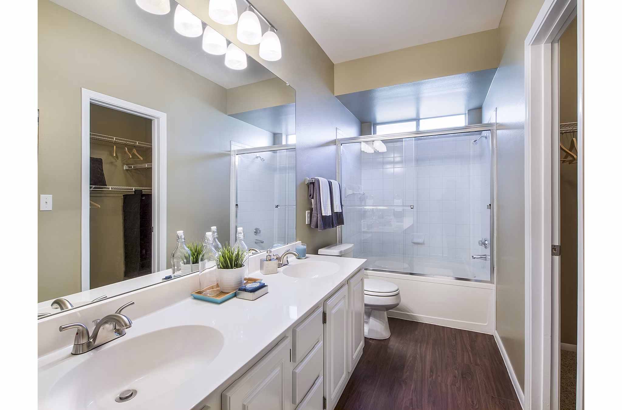 Modern bathroom featuring a double sink vanity and glass shower door at luxury apartments