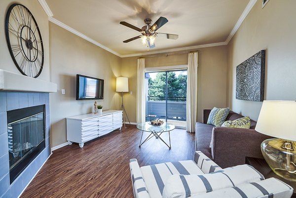 Living room with contemporary decor featuring plush seating and large windows at Monte Vista Apartments in Phoenix
