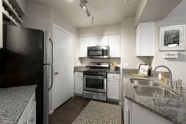 Contemporary kitchen with granite countertops and stainless steel appliances at Hardrock Canyon Apartments