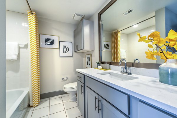 Luxurious bathroom featuring marble countertops and a spacious tub at Manchester State Thomas Apartments