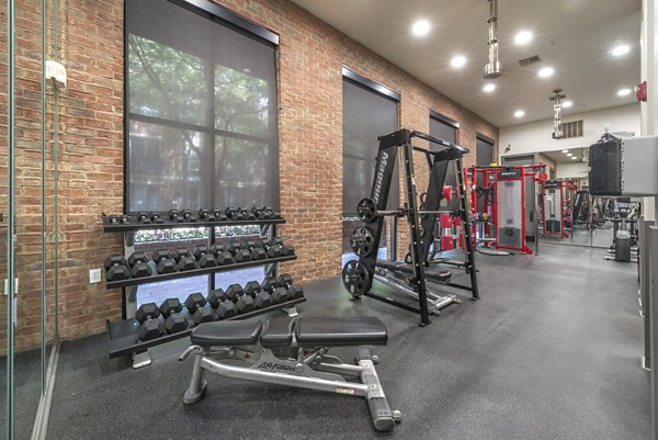 Fully-equipped fitness center with modern workout machines at Manchester State Thomas Apartments